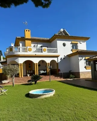 a large house with a fountain in the yard at Villa Atlántida-Playa La Barrosa in Chiclana de la Frontera