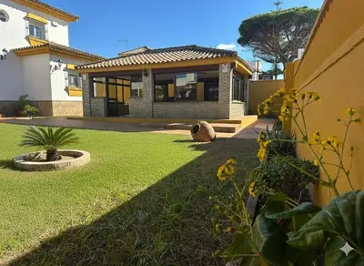 a house with a lawn in front of it at Villa Atlántida-Playa La Barrosa in Chiclana de la Frontera