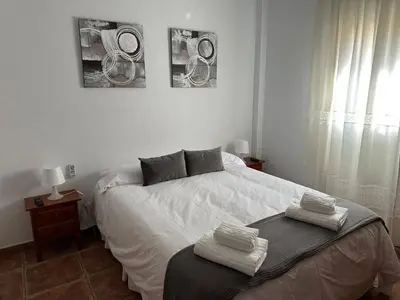 a bedroom with a bed with two towels on it at Villa Atlántida-Playa La Barrosa in Chiclana de la Frontera