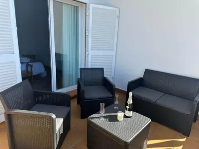 a living room with two chairs and a couch and a table at Villa Atlántida-Playa La Barrosa in Chiclana de la Frontera