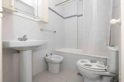 a white bathroom with a sink and a toilet at La Almadraba in Novo Sancti Petri
