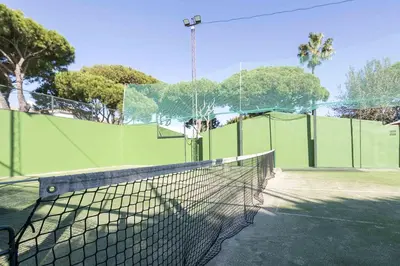 a tennis court with a net on a tennis court at La Almadraba in Novo Sancti Petri