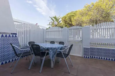 a table and chairs on a patio with a fence at La Almadraba in Novo Sancti Petri