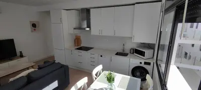 a kitchen and living room with a couch and a table at Cruces by LiveWork in El Puerto de Santa María