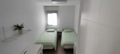 a room with two beds and a window at Cruces by LiveWork in El Puerto de Santa María