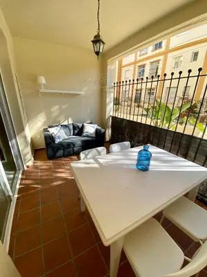 a living room with a white table and chairs at Playa Ballena Apartment in Chipiona