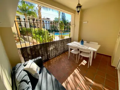 a balcony with a table and a white table and chairs at Playa Ballena Apartment in Chipiona