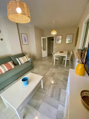 a living room with a couch and a table at Playa Ballena Apartment in Chipiona