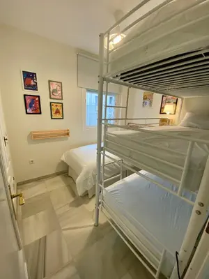 a bedroom with two bunk beds and a window at Playa Ballena Apartment in Chipiona