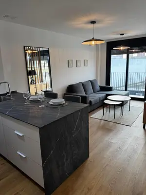 a kitchen and living room with a couch and a table at Ático Roomy in Jerez de la Frontera