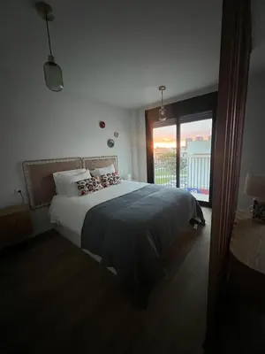 a bedroom with a large bed and a large window at Estudio Roomy Jerez in Jerez de la Frontera