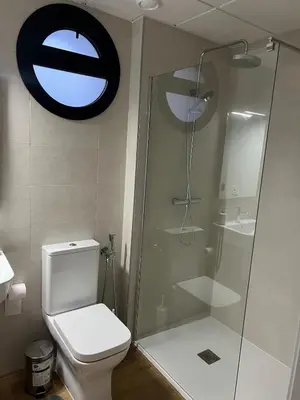 a bathroom with a toilet and a glass shower at Estudio Roomy Jerez in Jerez de la Frontera