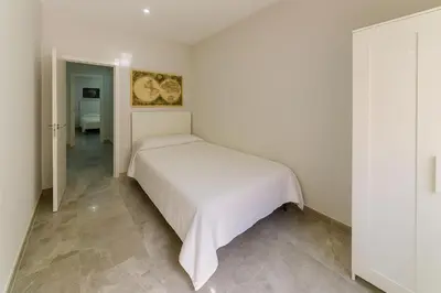 a white bedroom with a white bed in a room at Apartamento Luz de Cádiz in Cádiz