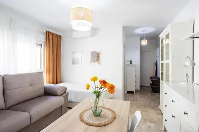 a living room with a couch and a table with flowers on it at San Felipe Neri Free Parking in Cádiz