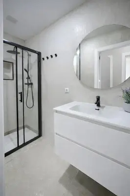 a white bathroom with a sink and a mirror at Apartamento Luz de Gadir in Cádiz