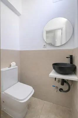 a bathroom with a white toilet and a mirror at Apartamento Luz de Gadir in Cádiz