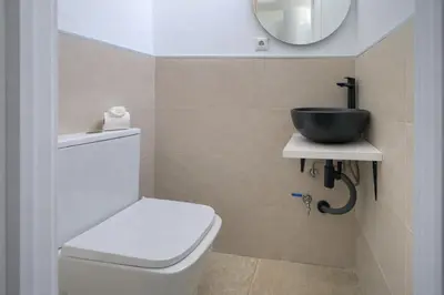 a bathroom with a sink and a toilet and a mirror at Apartamento Luz de Gadir in Cádiz