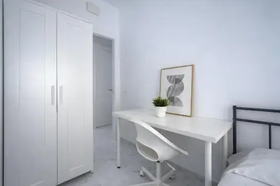 a white desk with a white chair in a bedroom at Apartamento Luz de Gadir in Cádiz