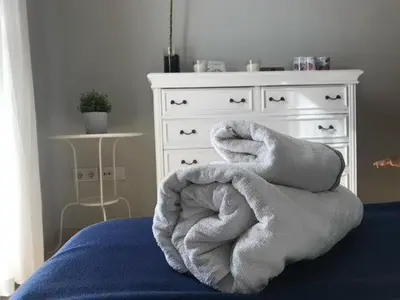 a bed with a pile of white towels on it at Renfurbis apartment in Jerez de la Frontera