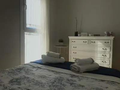 a bedroom with a bed with a dresser and towels at Renfurbis apartment in Jerez de la Frontera