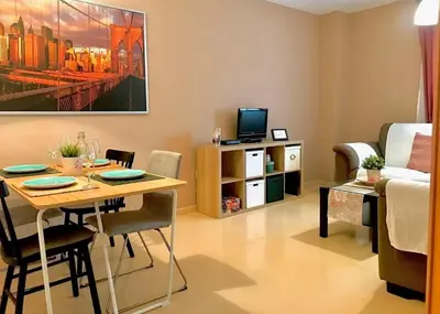 a living room with a table and a couch and a tv at Renfurbis apartment in Jerez de la Frontera