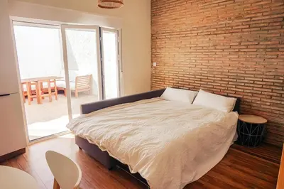 a bedroom with a large bed with a brick wall at Apartamento en pleno centro de Jerez con patio privado in Jerez de la Frontera