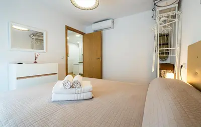 a bedroom with a bed with towels on it at YourHouse Apartamentos Andasol 1D in Chipiona