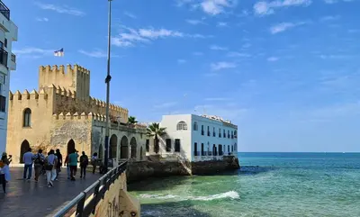 a group of people walking on a pier next to the ocean at YourHouse Apartamentos Andasol 1 I in Chipiona