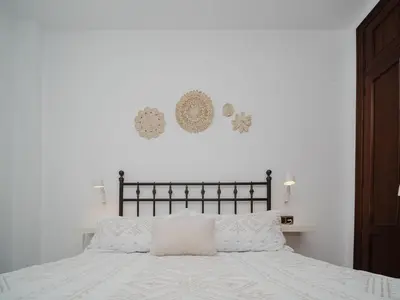 a bedroom with a bed with white sheets and pillows at Winahost Apartamento Sanlúcar de Barrameda in Sanlúcar de Barrameda