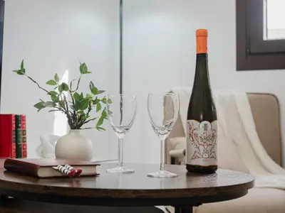 a bottle of wine and two wine glasses on a table at Winahost Apartamento Sanlúcar de Barrameda in Sanlúcar de Barrameda