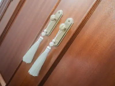 two white tassles hanging on a wooden door at Winahost Apartamento Sanlúcar de Barrameda in Sanlúcar de Barrameda