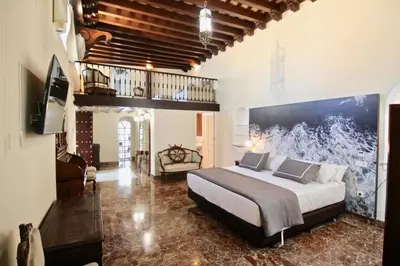a bedroom with a large bed with a large painting on the wall at El Palacete del Puerto in El Puerto de Santa María