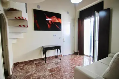a living room with a table and a painting on the wall at El Palacete del Puerto in El Puerto de Santa María