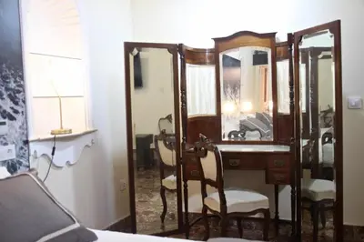 a bedroom with a dressing table and a mirror at El Palacete del Puerto in El Puerto de Santa María