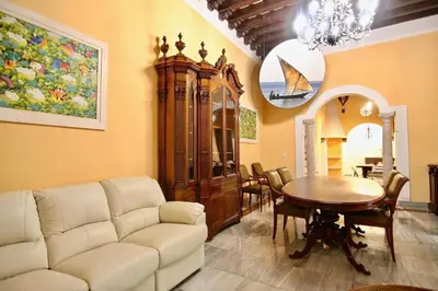a living room with a white couch and a table at El Palacete del Puerto in El Puerto de Santa María