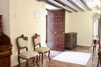 a room with two chairs and a door at El Palacete del Puerto in El Puerto de Santa María