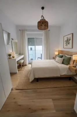 a bedroom with a bed and a desk and a window at El Olivar de Sol in Jerez de la Frontera