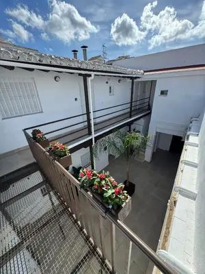 a balcony with flowers and plants on a building at El Olivar de Sol in Jerez de la Frontera