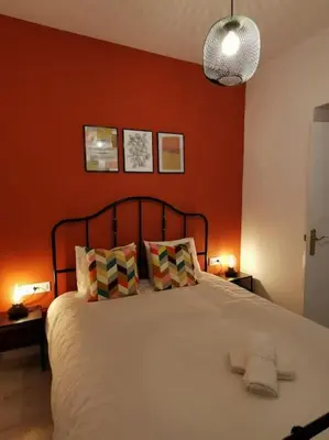 a bedroom with a large bed with orange walls at CDZ - Buenos Aires en Cádiz in Cádiz