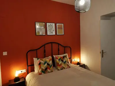 a bedroom with orange walls and a bed with two lamps at CDZ - Buenos Aires en Cádiz in Cádiz