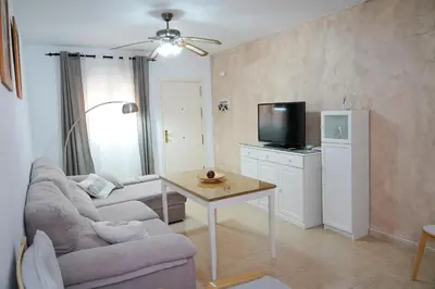 a living room with a couch and a table and a tv at Bajamar in Sanlúcar de Barrameda