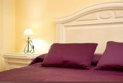 a bed with purple sheets and a white headboard at Bajamar in Sanlúcar de Barrameda