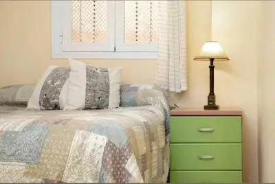 a bedroom with a bed and a lamp on a dresser at Bajamar in Sanlúcar de Barrameda