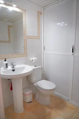a bathroom with a sink and a toilet and a mirror at Bajamar in Sanlúcar de Barrameda