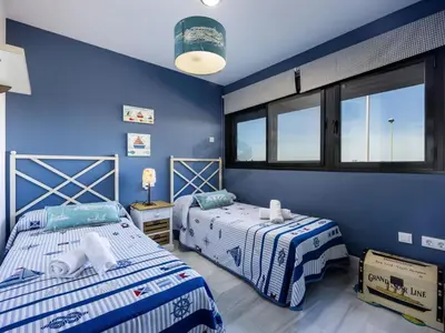 two beds in a room with blue walls and windows at Villa Sol Sal free parking by Staycare in Rota