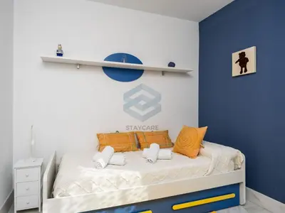 a bedroom with a bed with a blue wall at Villa Sol Sal free parking by Staycare in Rota