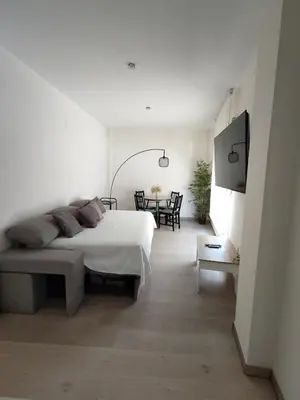 a bedroom with a bed and a table with chairs at Moderno apartamento en el centro de Jerez in Jerez de la Frontera