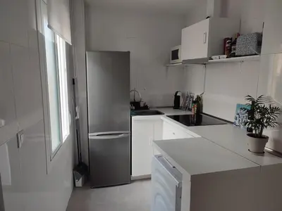 a kitchen with a stainless steel refrigerator and white cabinets at Moderno apartamento en el centro de Jerez in Jerez de la Frontera