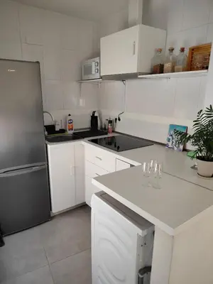 a kitchen with white cabinets and a stainless steel refrigerator at Moderno apartamento en el centro de Jerez in Jerez de la Frontera