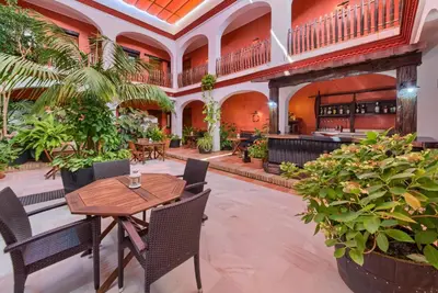 a restaurant with a table and chairs and plants at Hotel Pozo Rey by Youroom in Chipiona